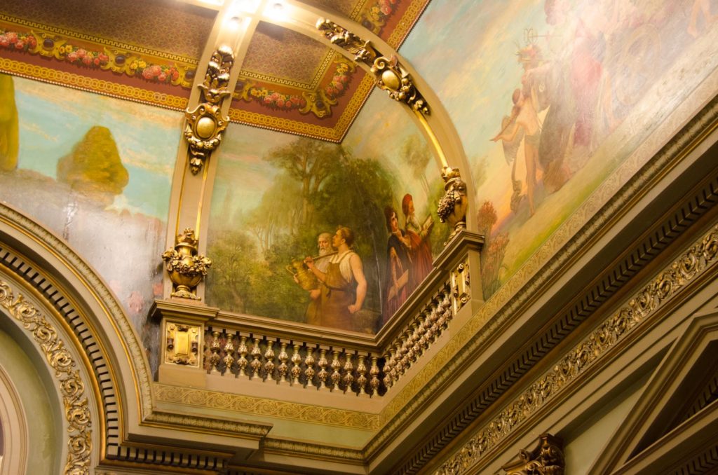 The cove of the grand staircase is decorated with painted rustic scenes